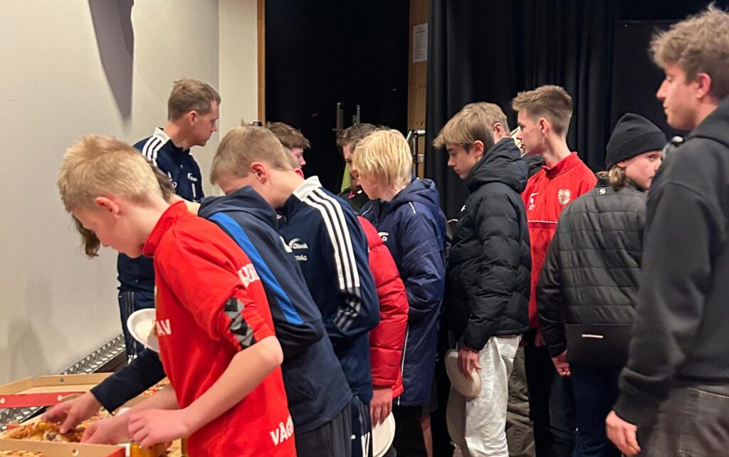 Ungdommer som forsyner seg av pizza og brus.